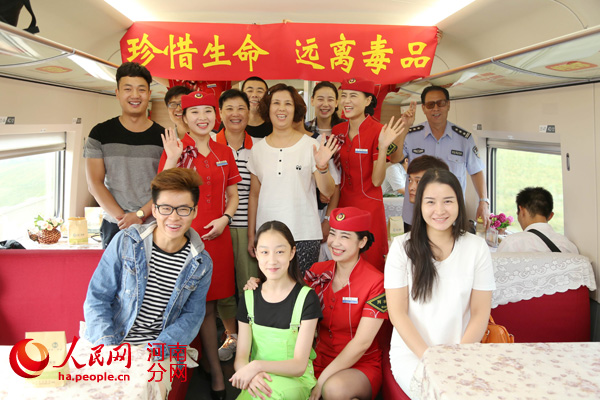 高铁姑娘和旅客们在“珍惜生命、远离毒品”条幅”条幅下合影留念