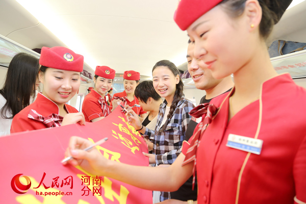 高铁姑娘和旅客们在“珍惜生命、远离毒品”条幅上签名