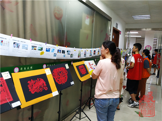 禁毒小义工在为来访群众讲解伪装毒品和禁毒漫画