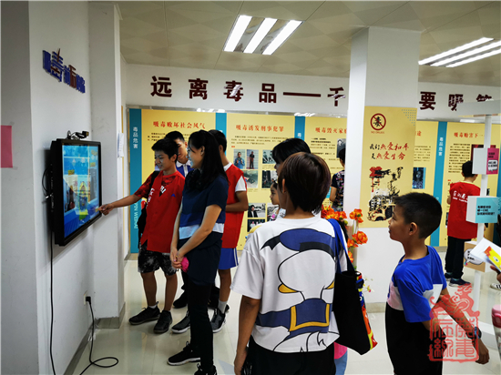 禁毒小义工在为来访群众操作”吸毒前后的你“机器